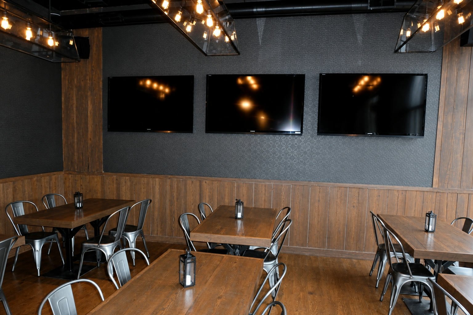 Blue Bar dining area with custom tables, steel stools, and warm wood finishes