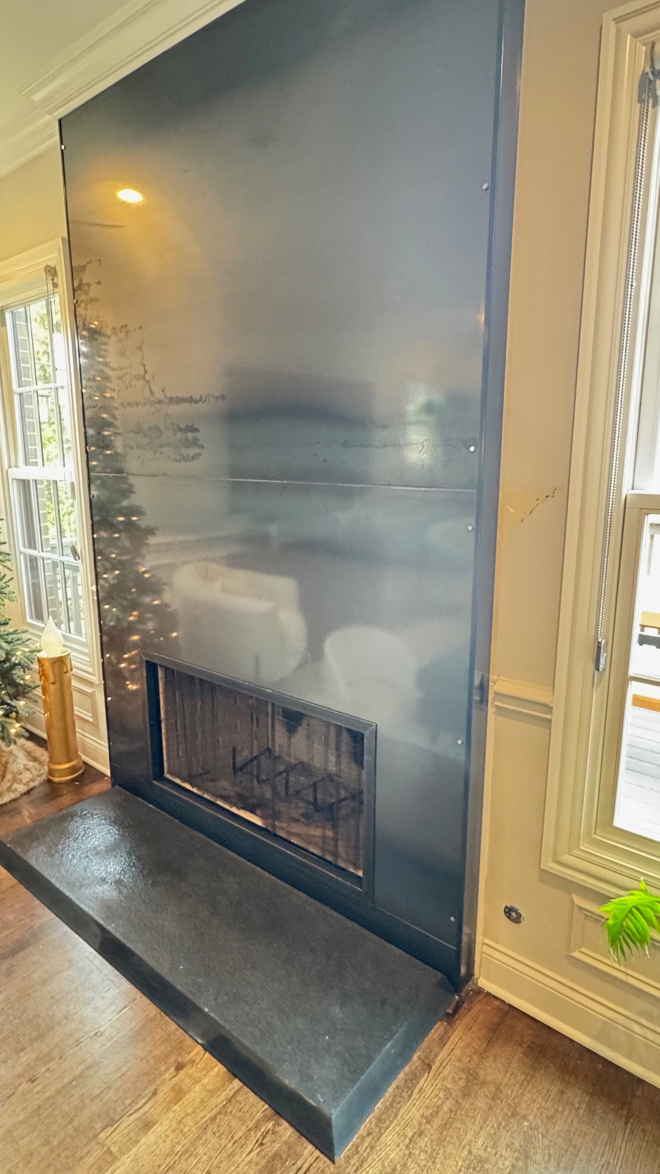 Dark custom metal fireplace panel in a finished living space