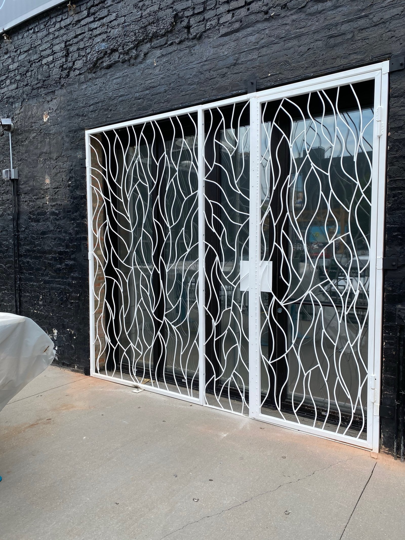 Stone-framed section of the Moca facade with vine-pattern metalwork
