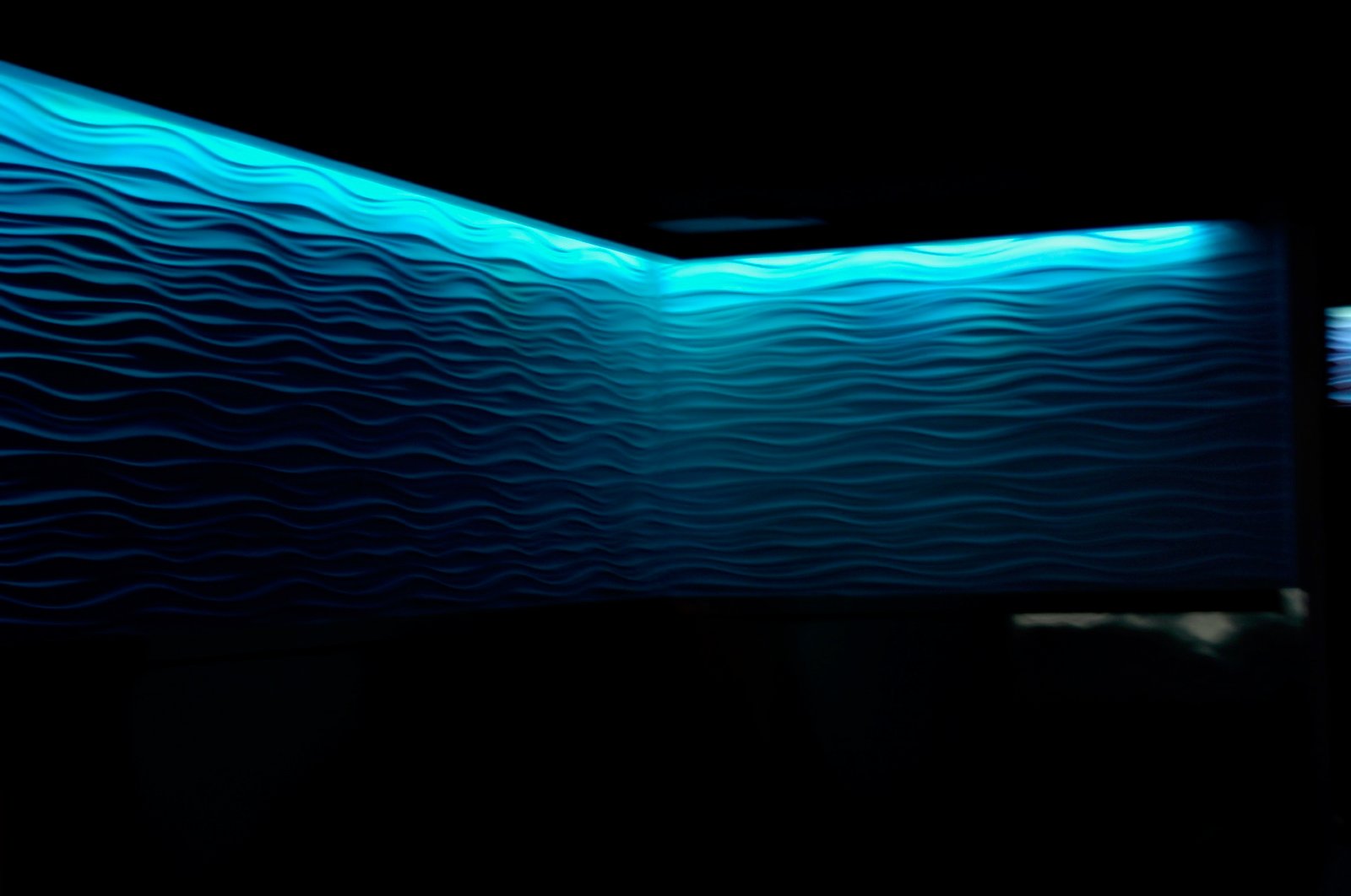 Blue Bar interior with a glowing blue wave wall and layered lighting